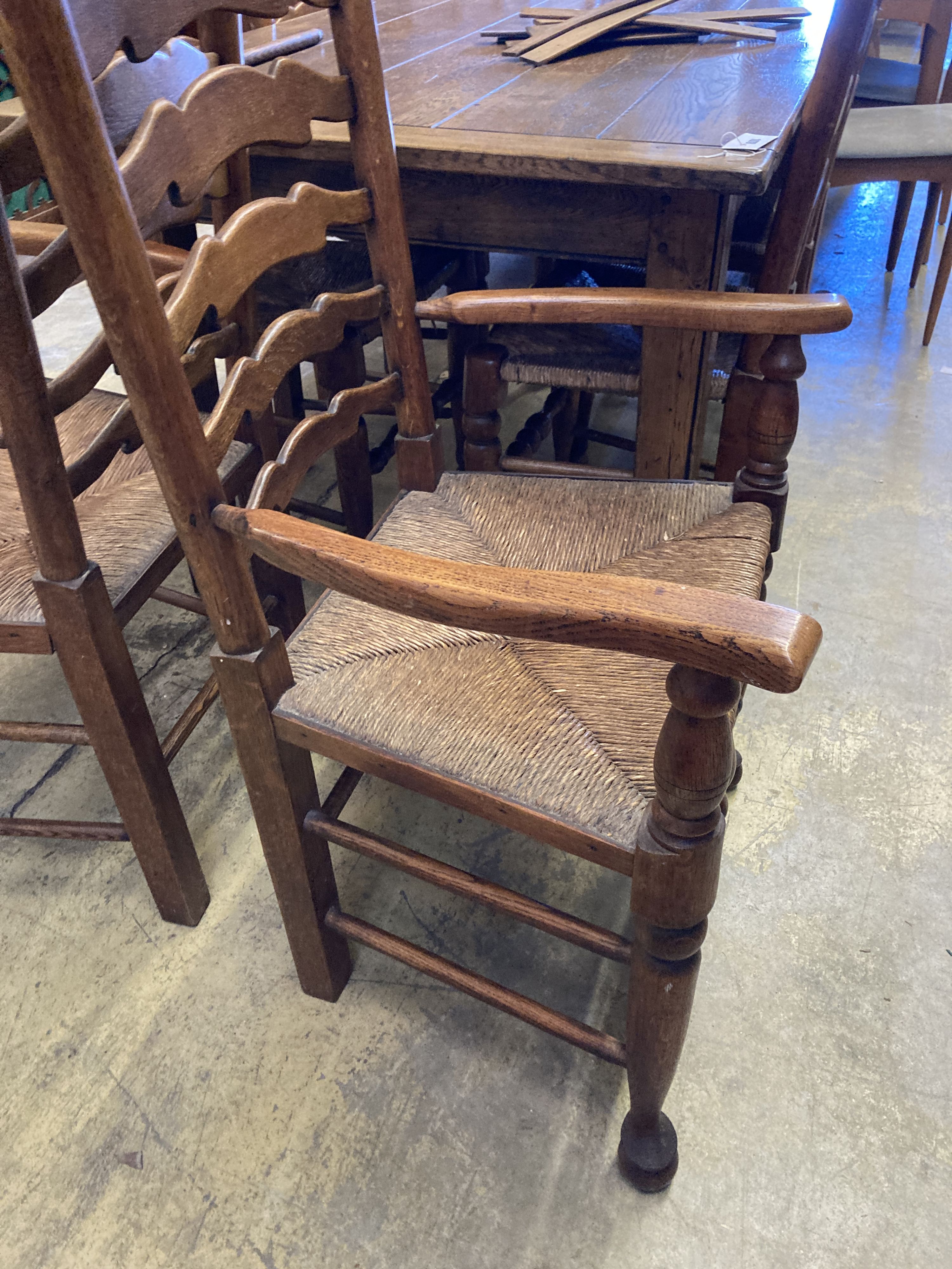 A set of six ladderback dining chairs with rush seats, two having arms